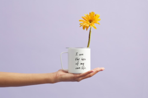 Person holding a mug with a flower